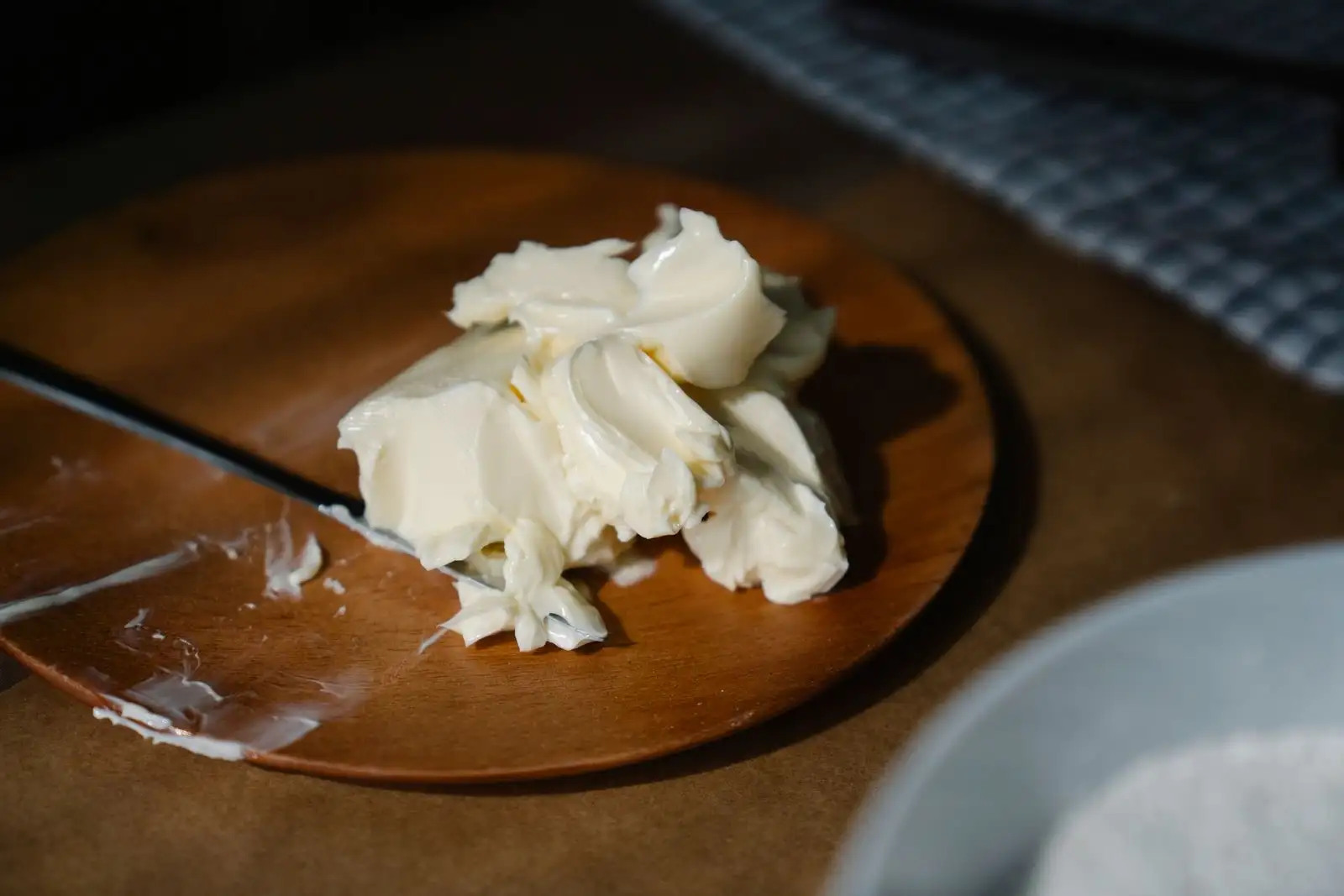 Softened butter worked with a knife on a round wooden board