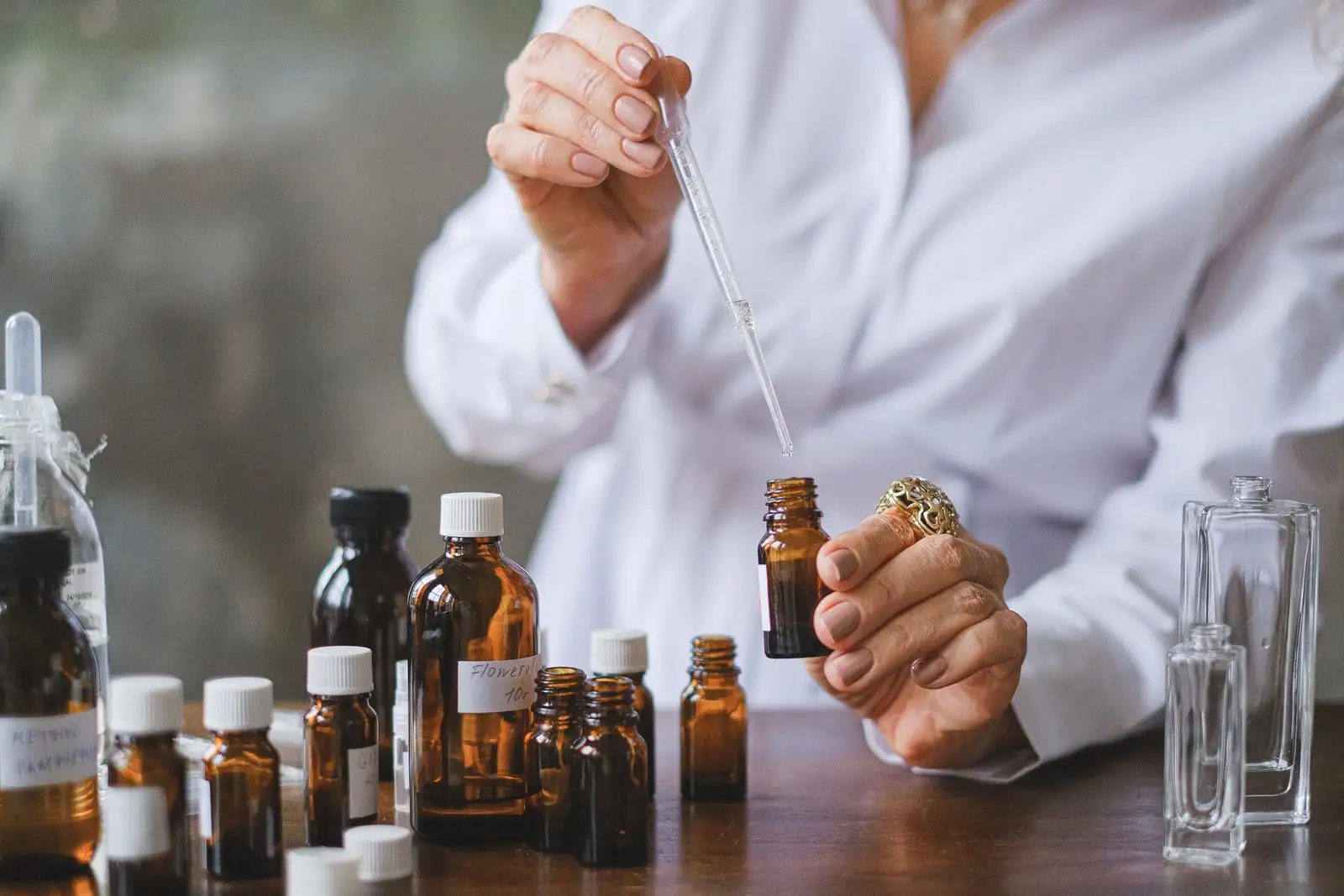 Hand-labelled amber glass bottles on a workbench while a pipette measures out a liquid