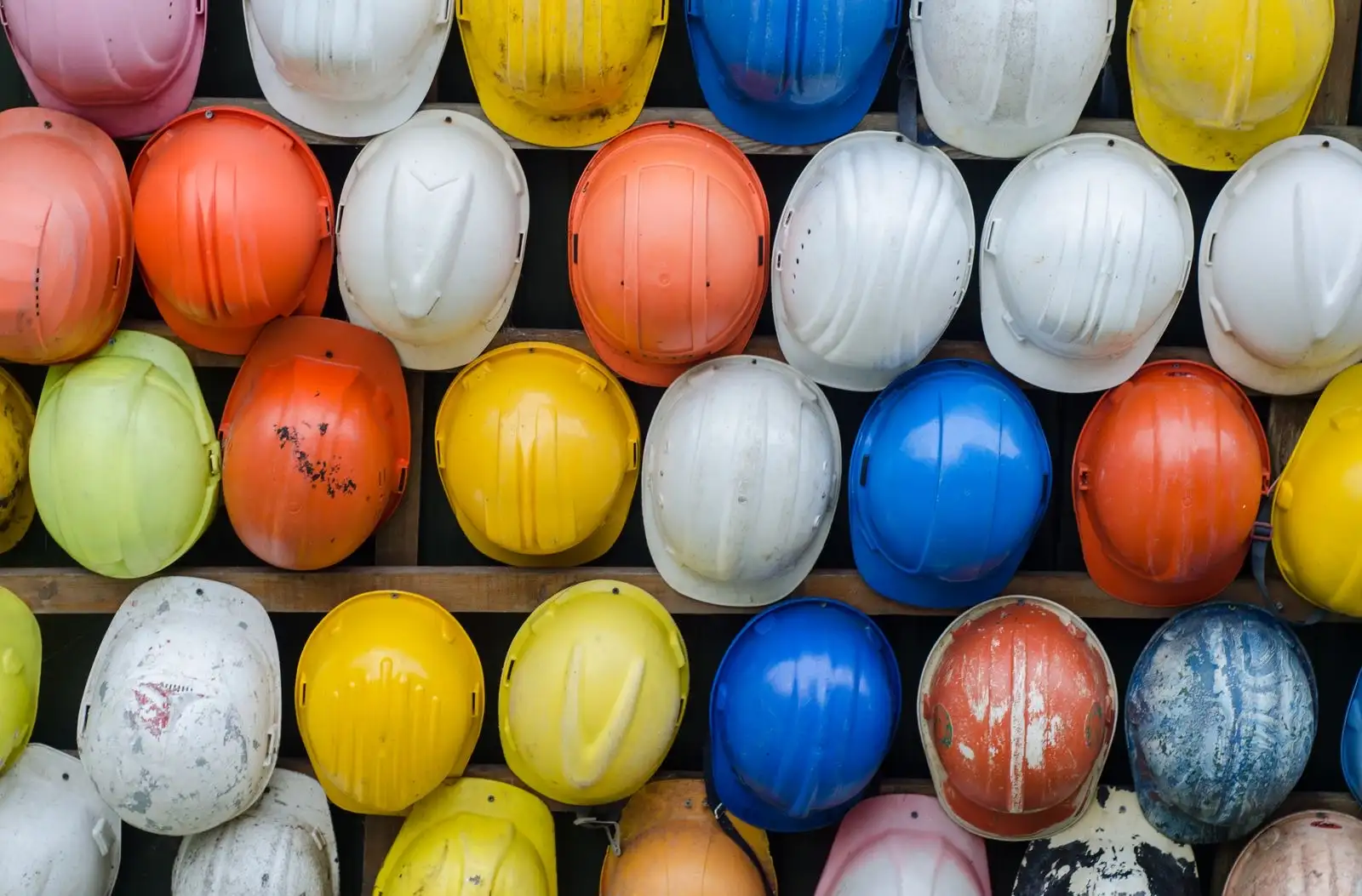 Hard hats of many colours lined up on shelves, the gear of safety-critical jobs where a drug test may be provided for