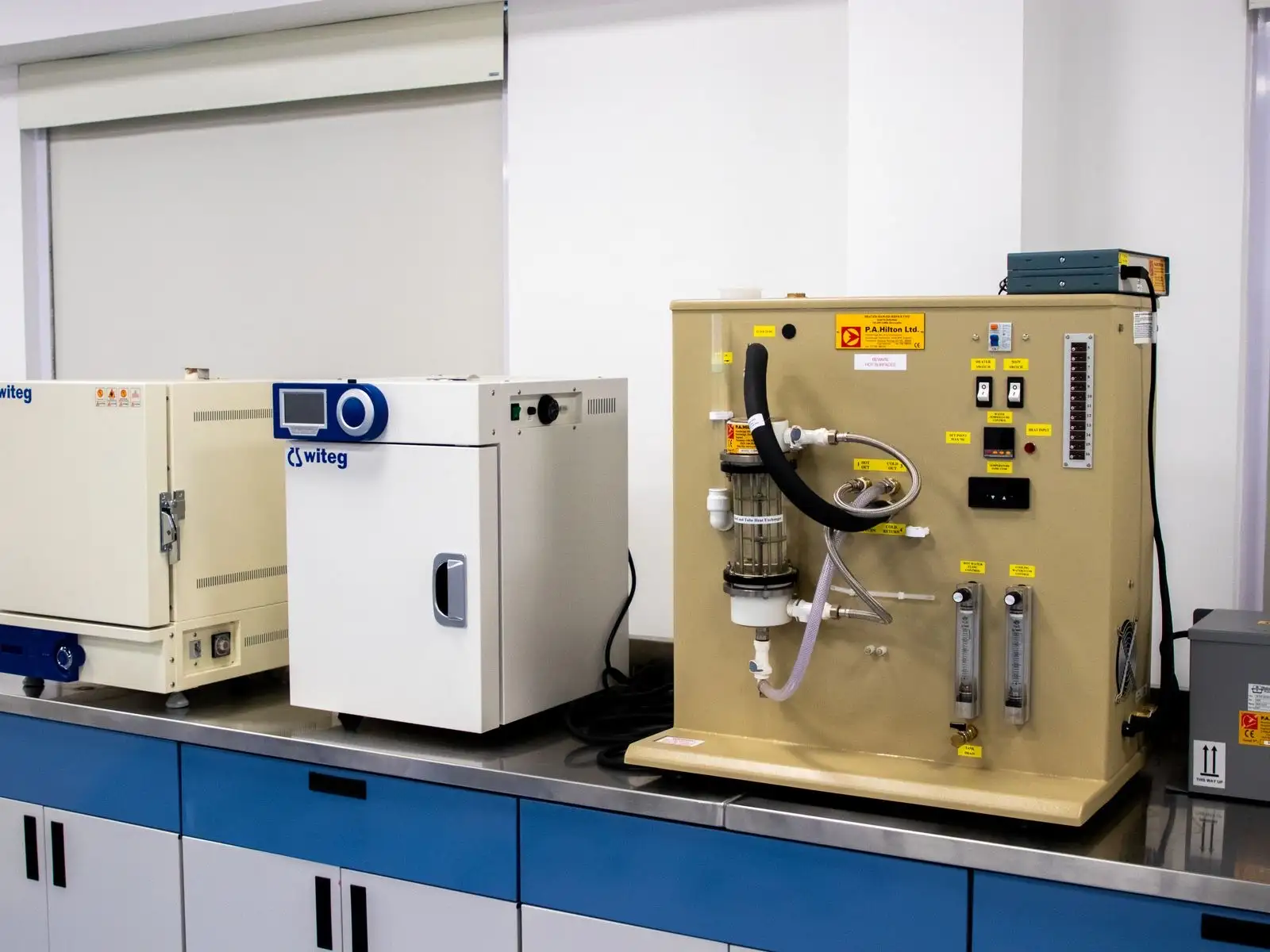 Laboratory bench with ovens and a test rig fitted with tubing and flow meters