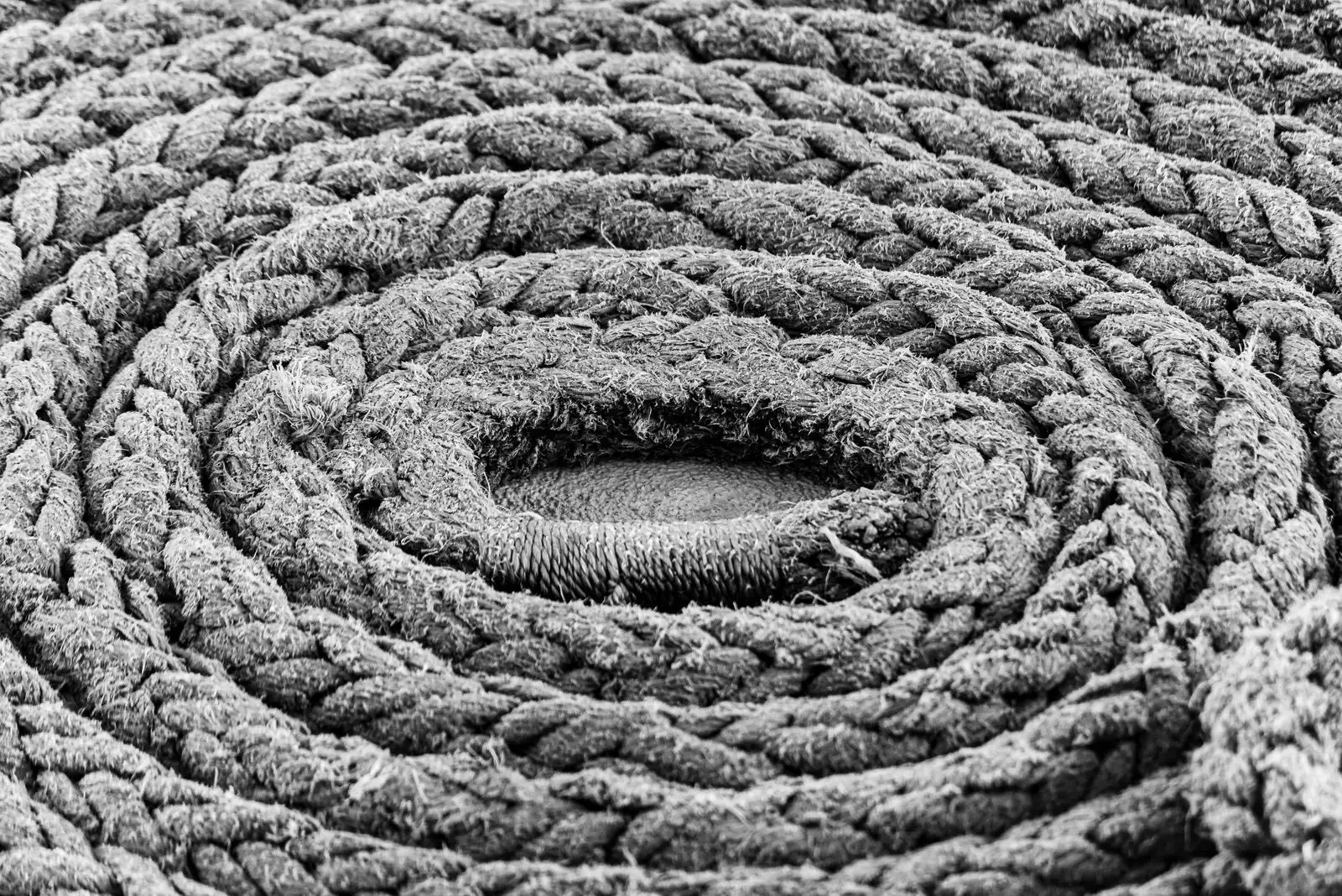 Braided rope coiled on itself, close up in black and white