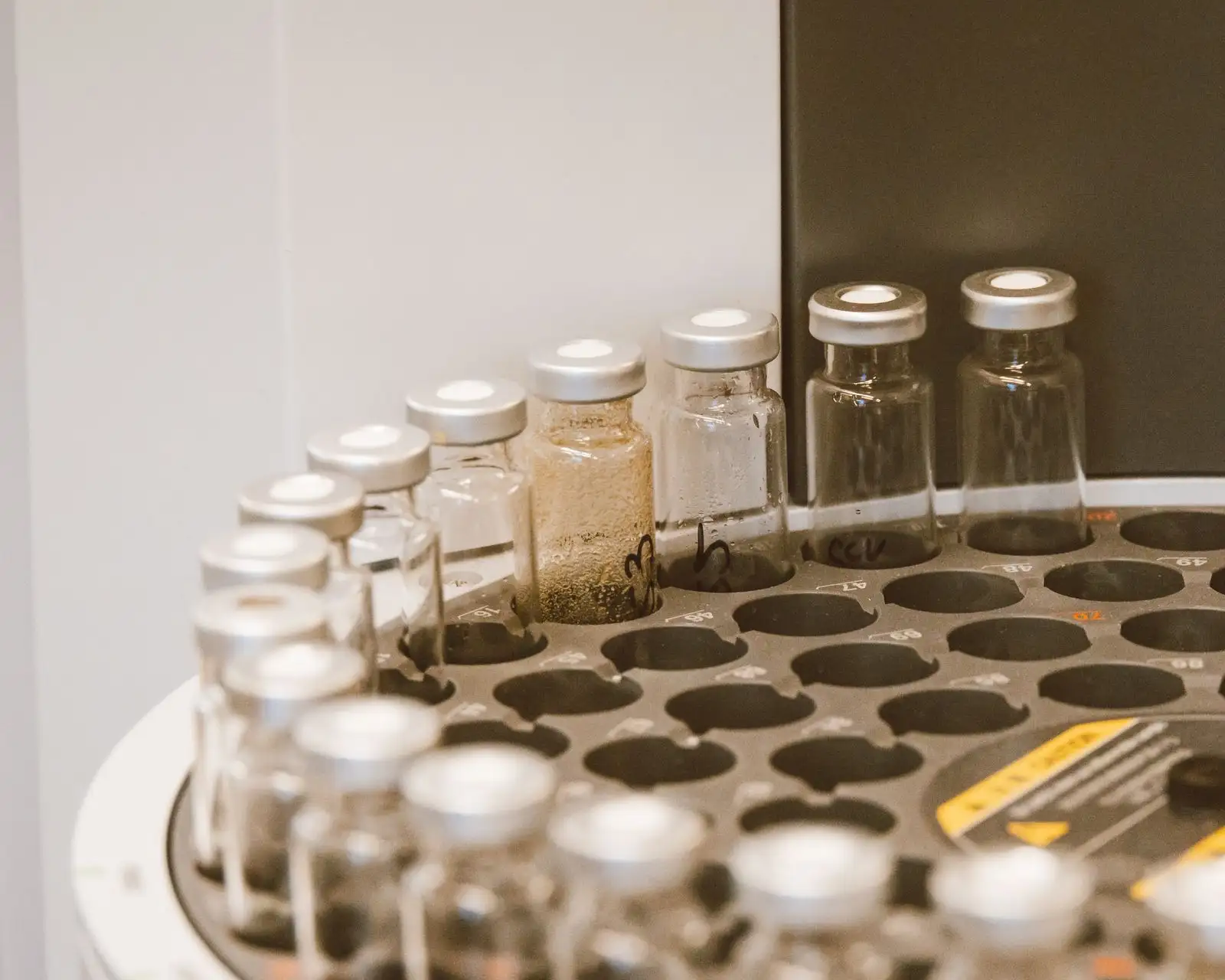 Capped sample vials in the tray of a chromatograph autosampler in a laboratory