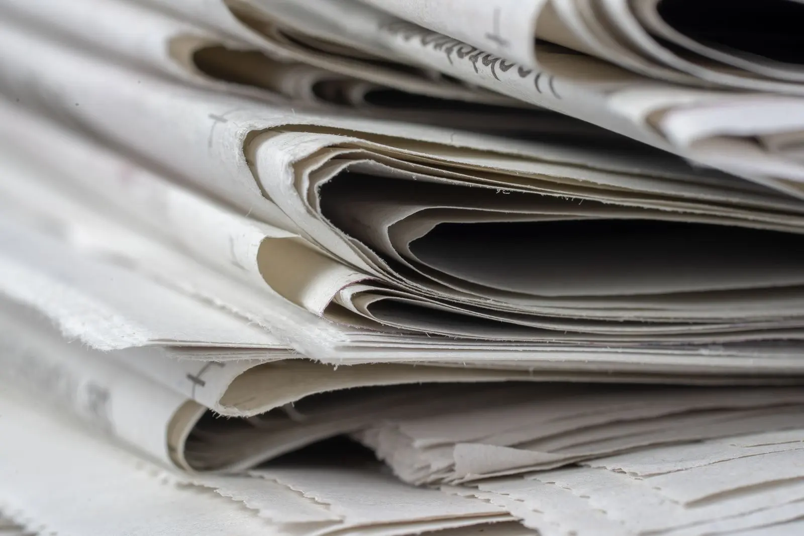 Close-up of a stack of folded newspapers, a picture of the media coverage of celebrity brands
