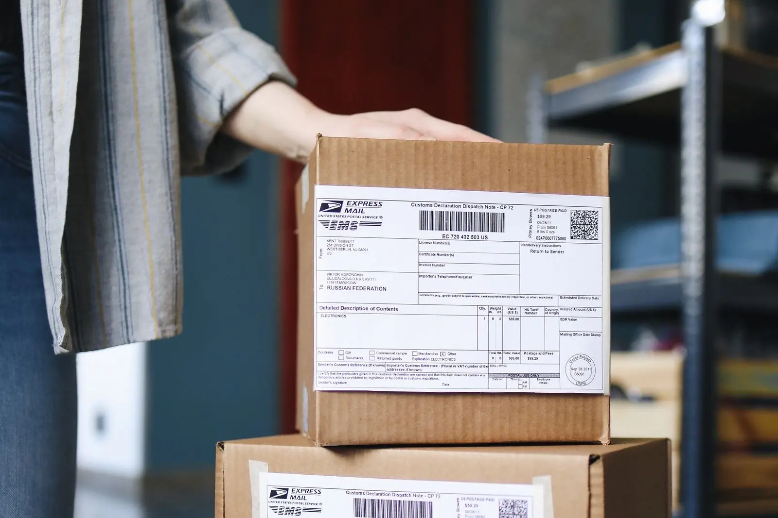 Cardboard parcels stacked on top of each other, carrying a CP 72 customs declaration with a barcode