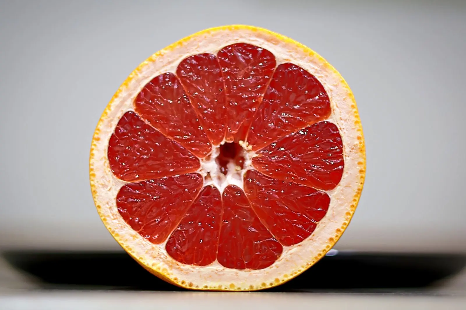 Close-up of a halved pink grapefruit, the fruit whose interactions with medicines are the most studied