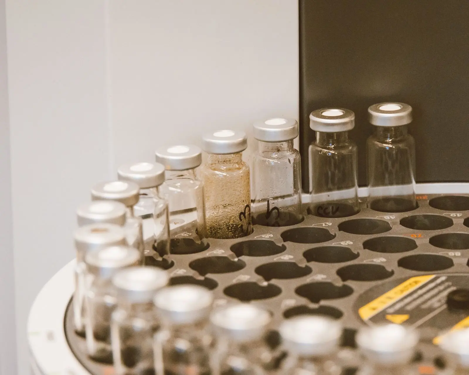 Capped sample vials in the tray of a chromatograph autosampler in a laboratory