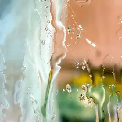 Gouttes de condensation sur une paroi de verre, reflets pastel