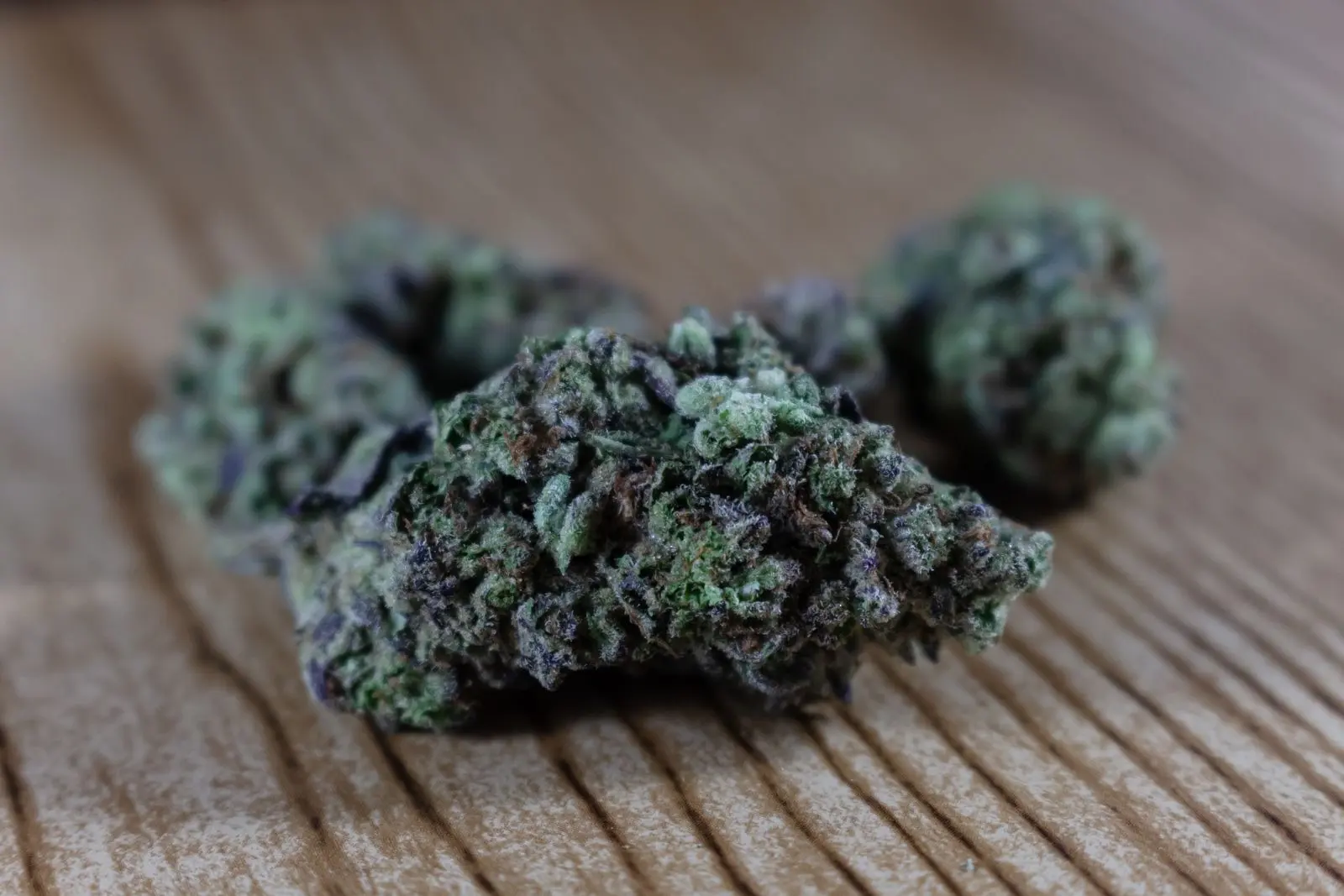 Dense, dark hemp buds on a wooden board, the base material of a moon rock before coating